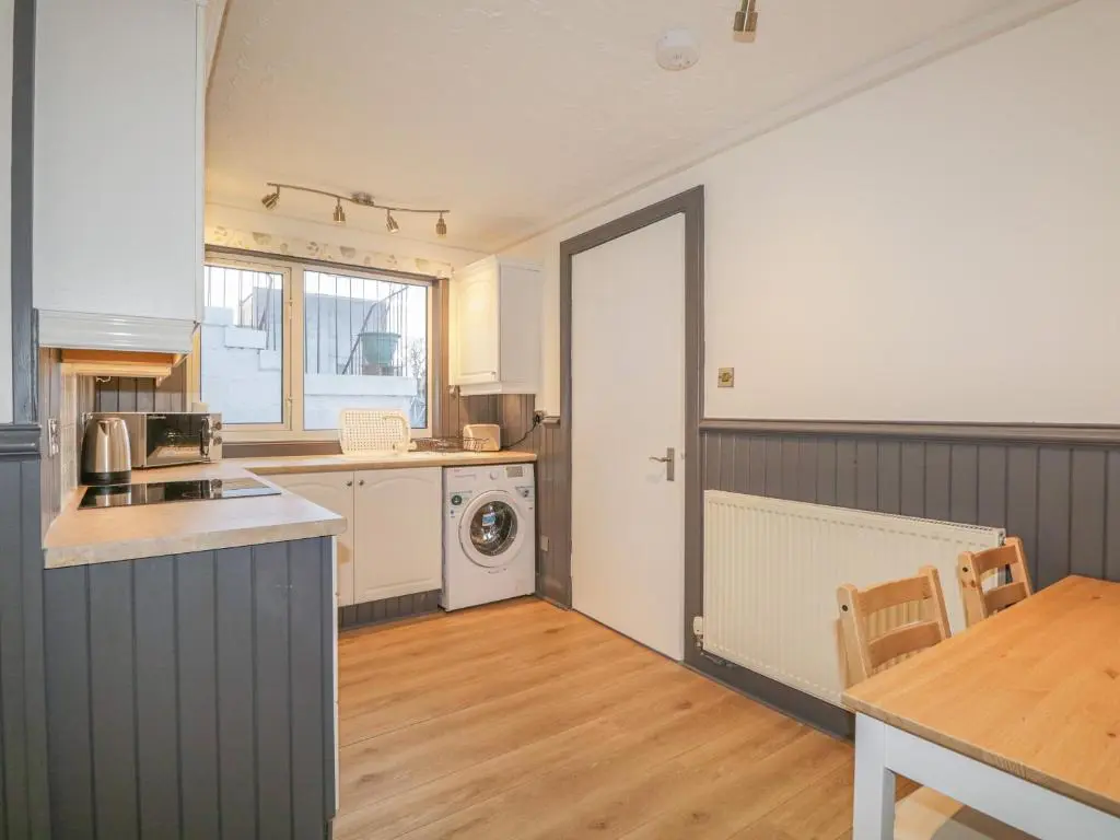 a kitchen with a washer and dryer in a room at The Neuk in Elgin