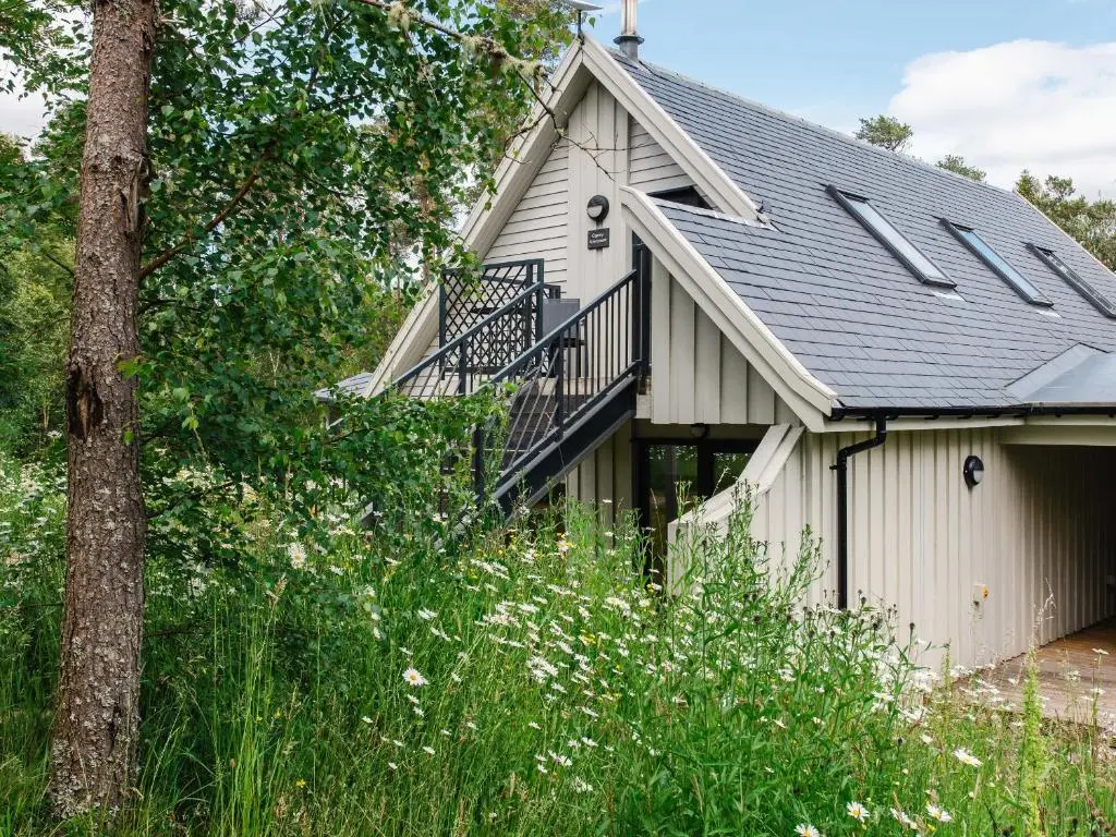 a house with a porch and a balcony at Osprey Apartment in Kingussie