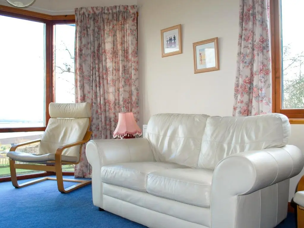 a living room with a white couch and a chair at Callachy Cottage - Uk7047 in Glenurguhart