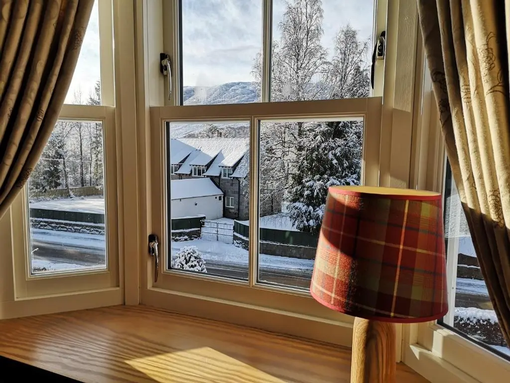 a room with a window looking out at a snow covered yard at Cranford Guest House in Braemar