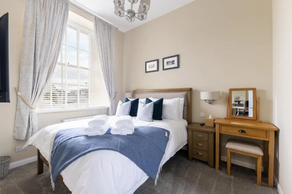 a bedroom with a bed with towels on it at Old Edinburgh Court in Inverness