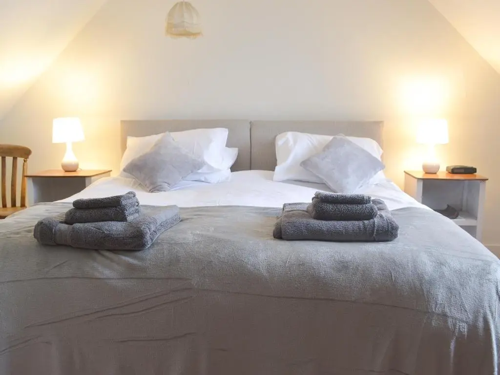 a bedroom with a bed with two towels on it at Crofts in Badenyon
