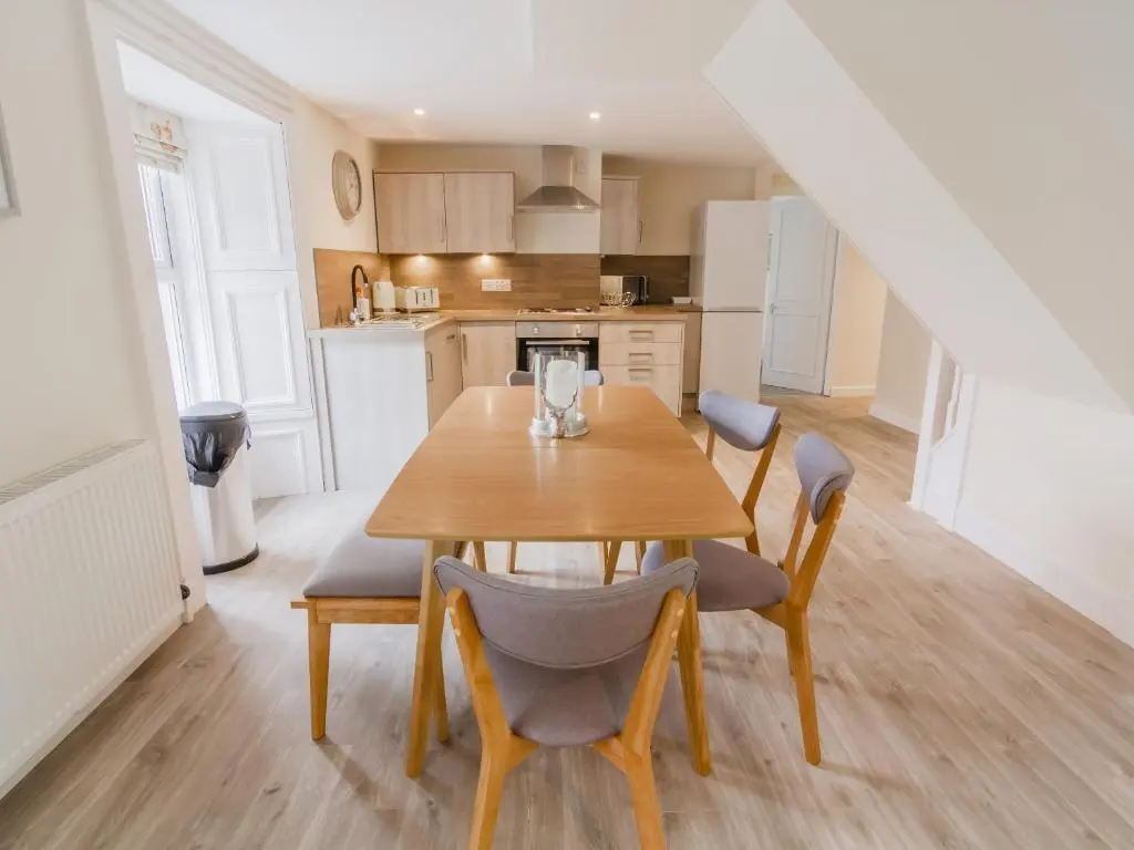 a kitchen and dining room with a wooden table and chairs at Dalnaglar Cottage - Uk30260 in Cray