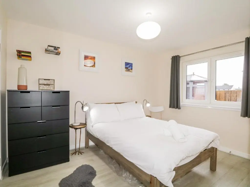 a bedroom with a bed and a window at Skoglendi in Boat of Garten