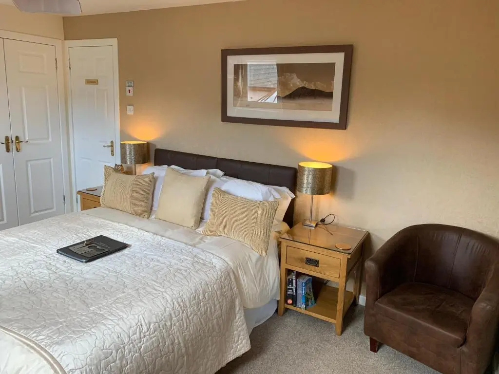 a hotel room with a bed and a chair at Silverstrands in Inverness