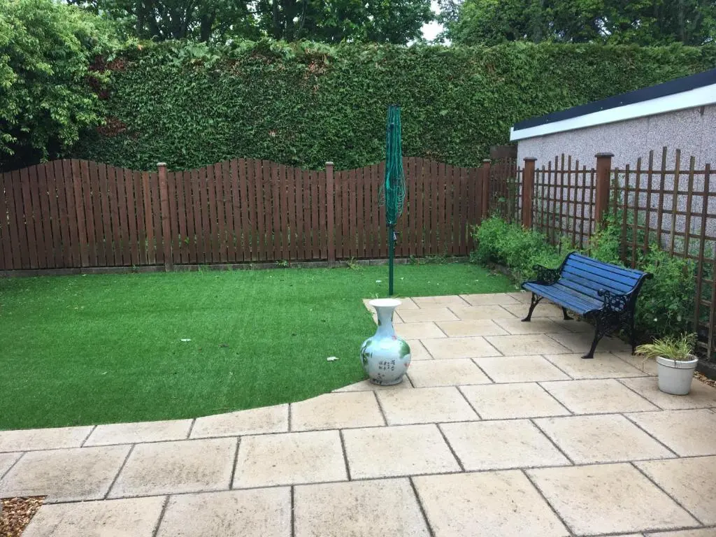 a garden with a bench and a green umbrella at Crescent Corner, Inverness in Inverness