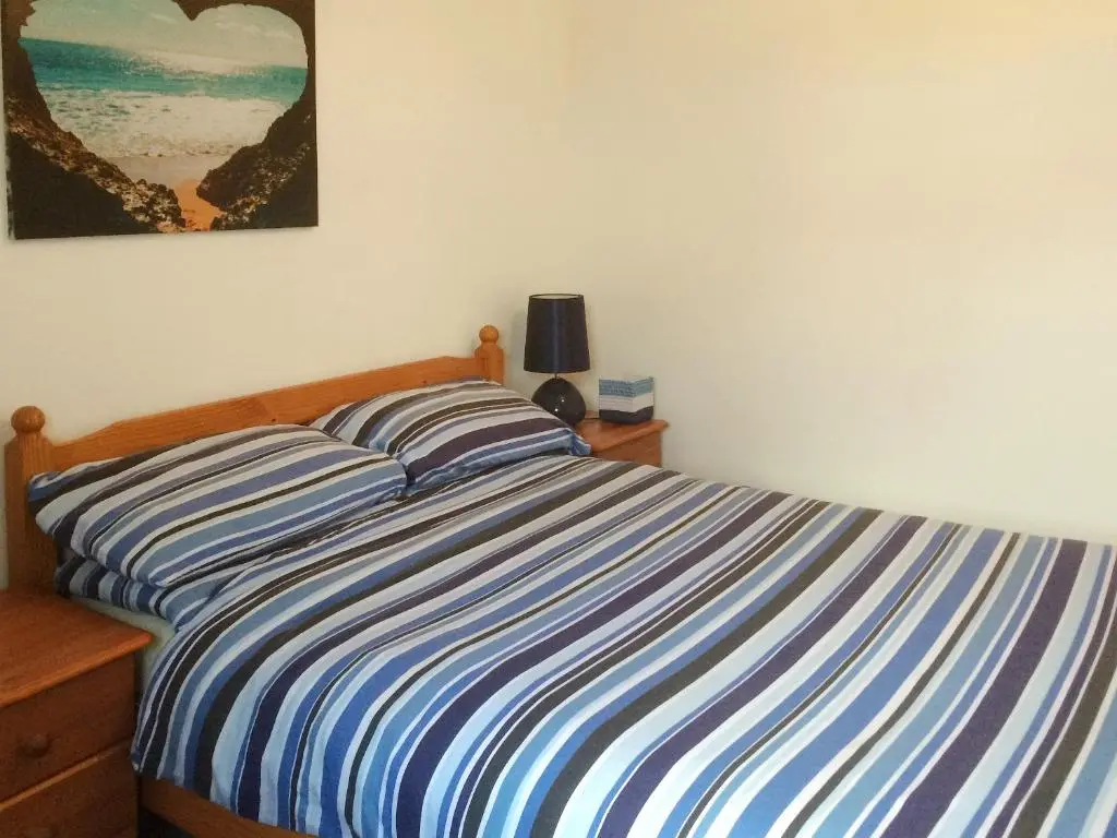 a bed with a blue and white striped comforter in a bedroom at Loch Ness - Uk7094 in Contin