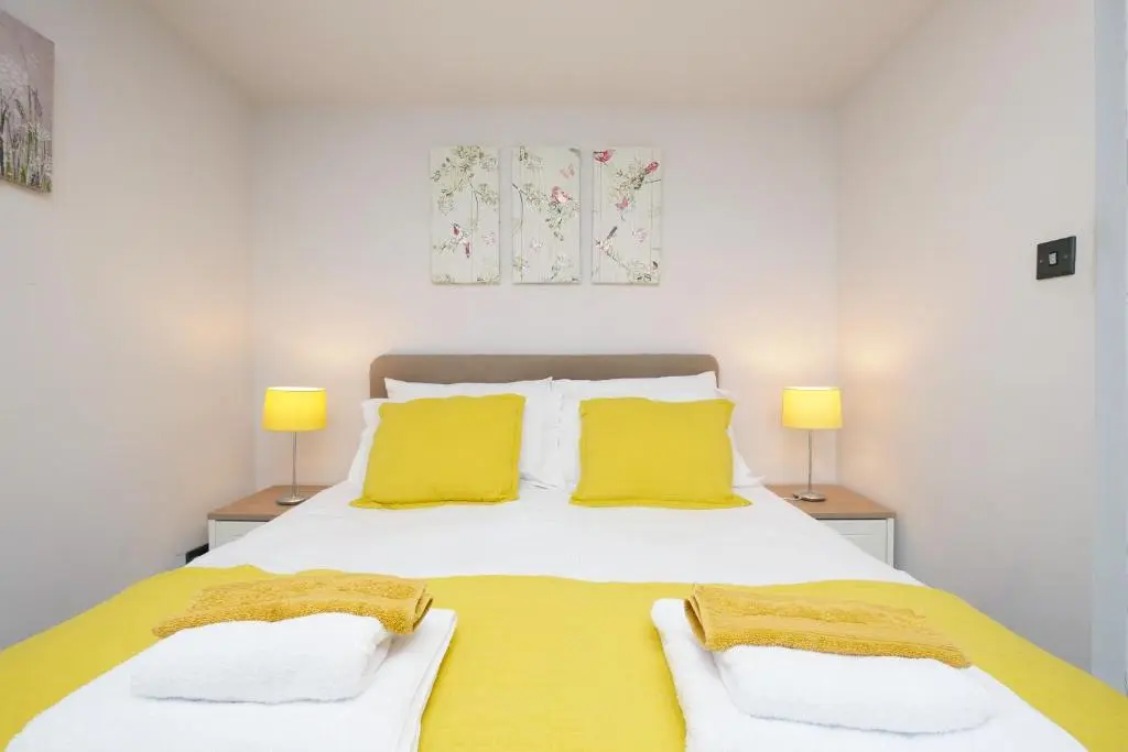 a bedroom with a large bed with yellow pillows at Ardentorrie Holiday Home in Inverness
