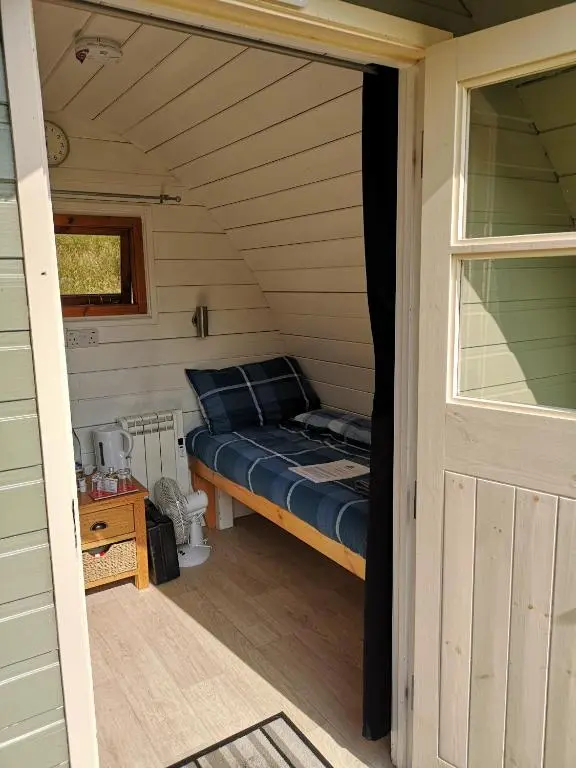 a small bedroom with a bed in a room at Craskie Glamping Pods in Inverness