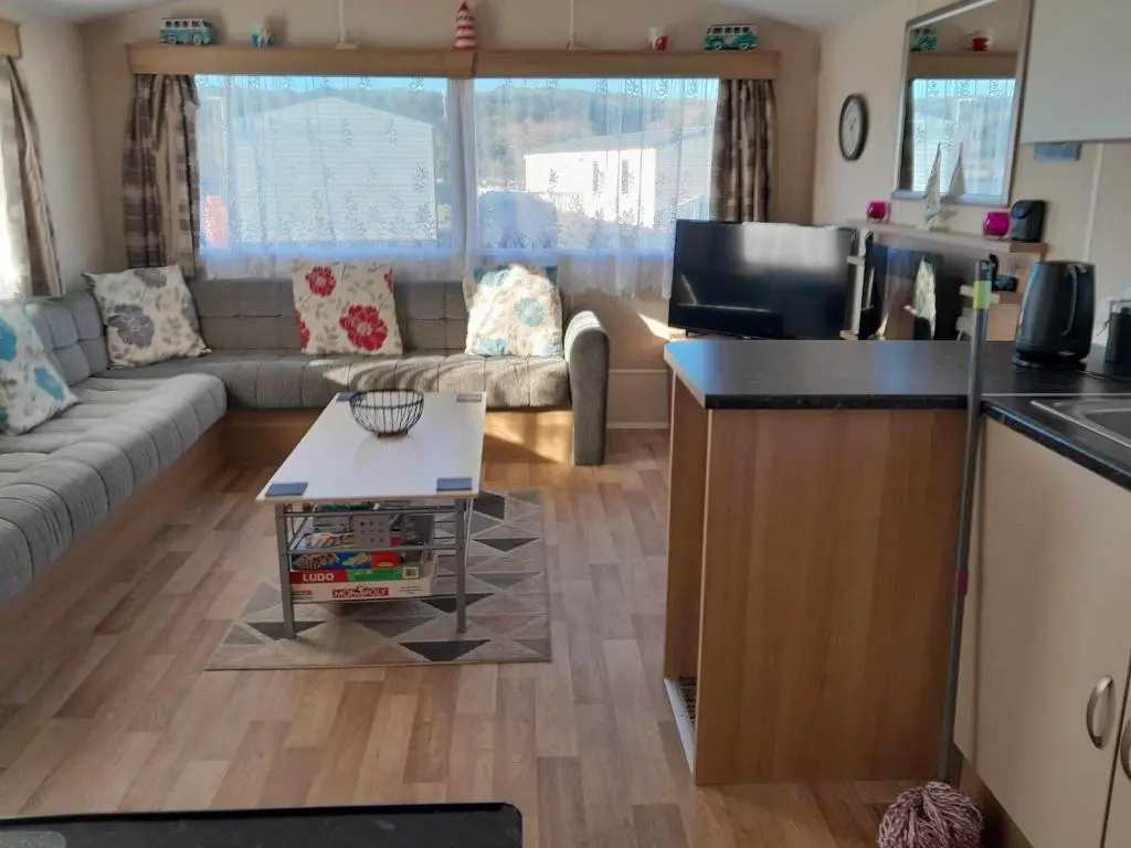 a kitchen and living room with a couch and a table at hollies retreat in Lossiemouth