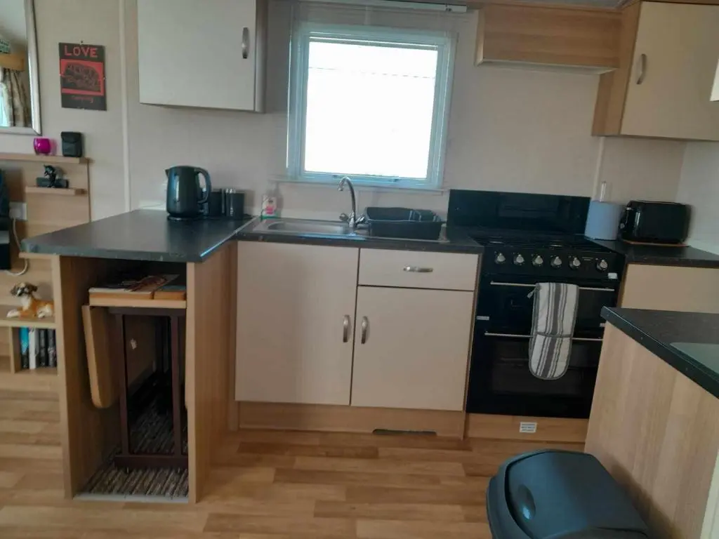 a small kitchen with a sink and a stove at hollies retreat in Lossiemouth