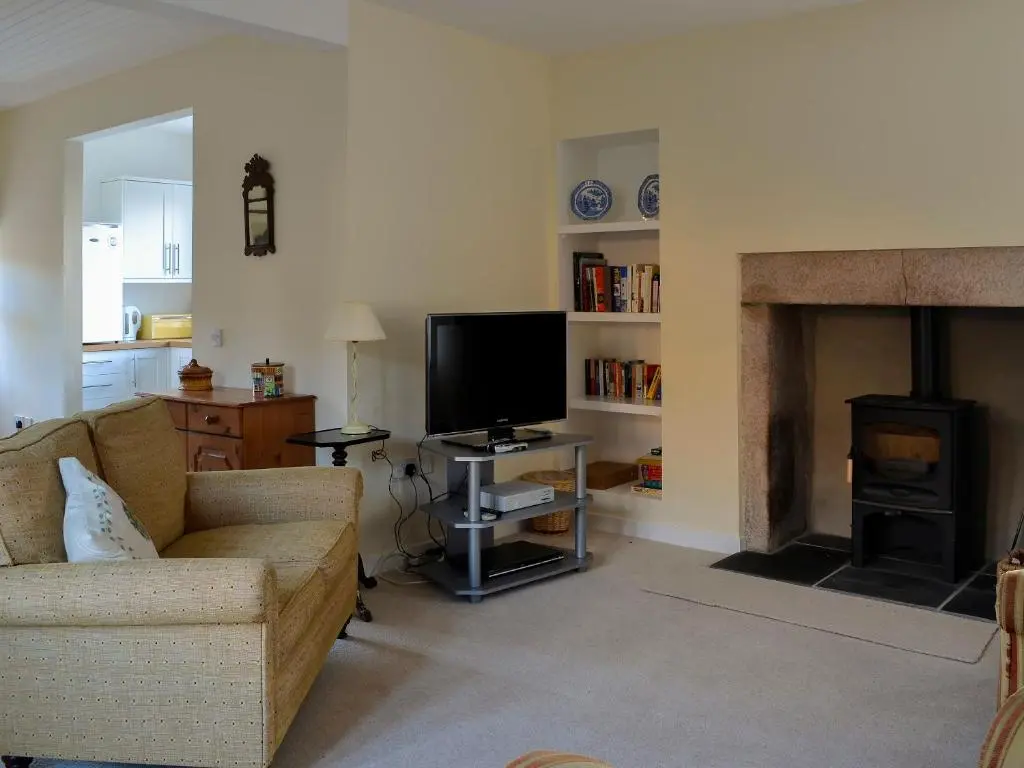 a living room with a couch and a fireplace at Dairy Cottage in Whitehouse