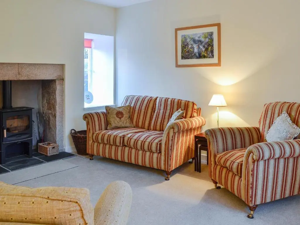 a living room with two couches and a fireplace at Dairy Cottage in Whitehouse