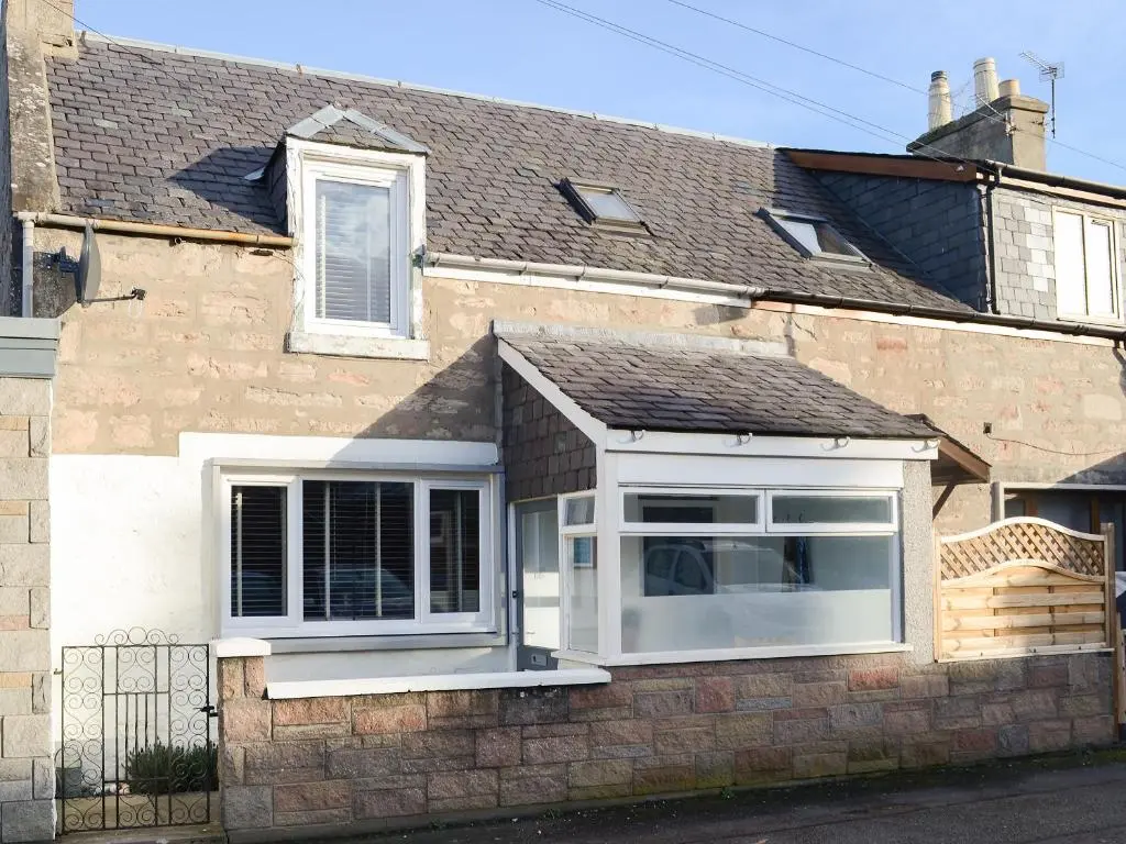 a window on the side of a brick house at Sea Thistle Cottage in Nairn
