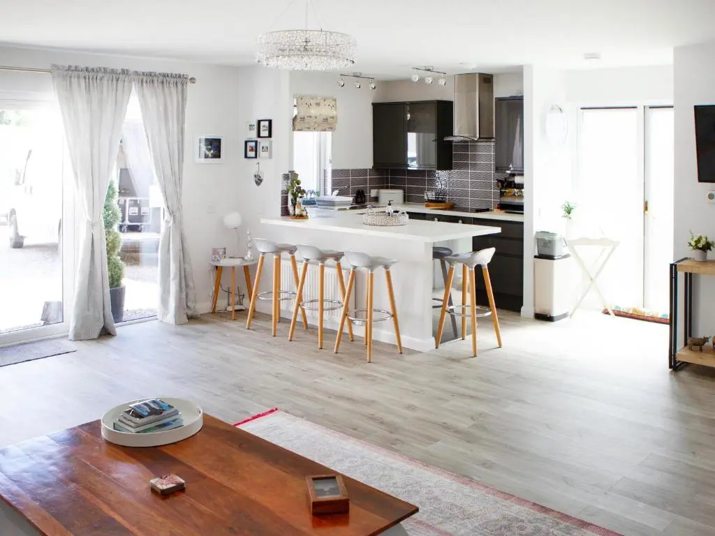 a kitchen and living room with a table and chairs at Rose Cottage in Dingwall