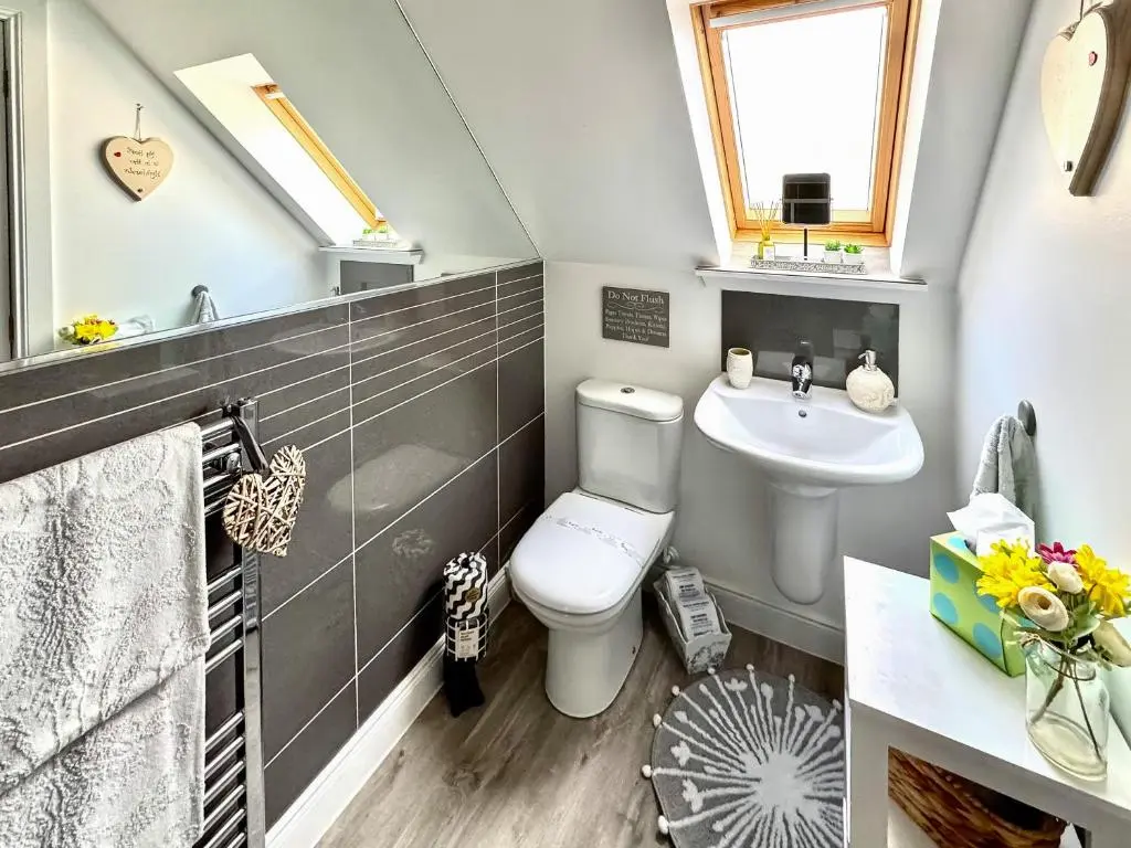 a bathroom with a toilet and a sink at Rose Cottage in Dingwall
