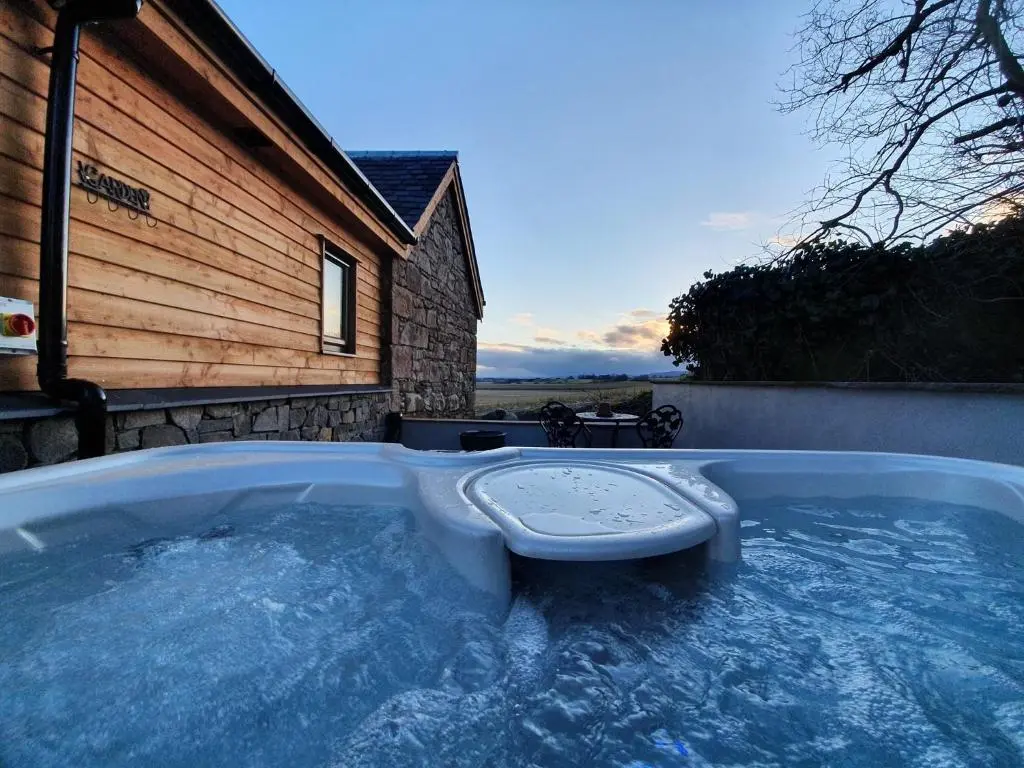 a hot tub in front of a house at The Auld Reekie in Barbaraville