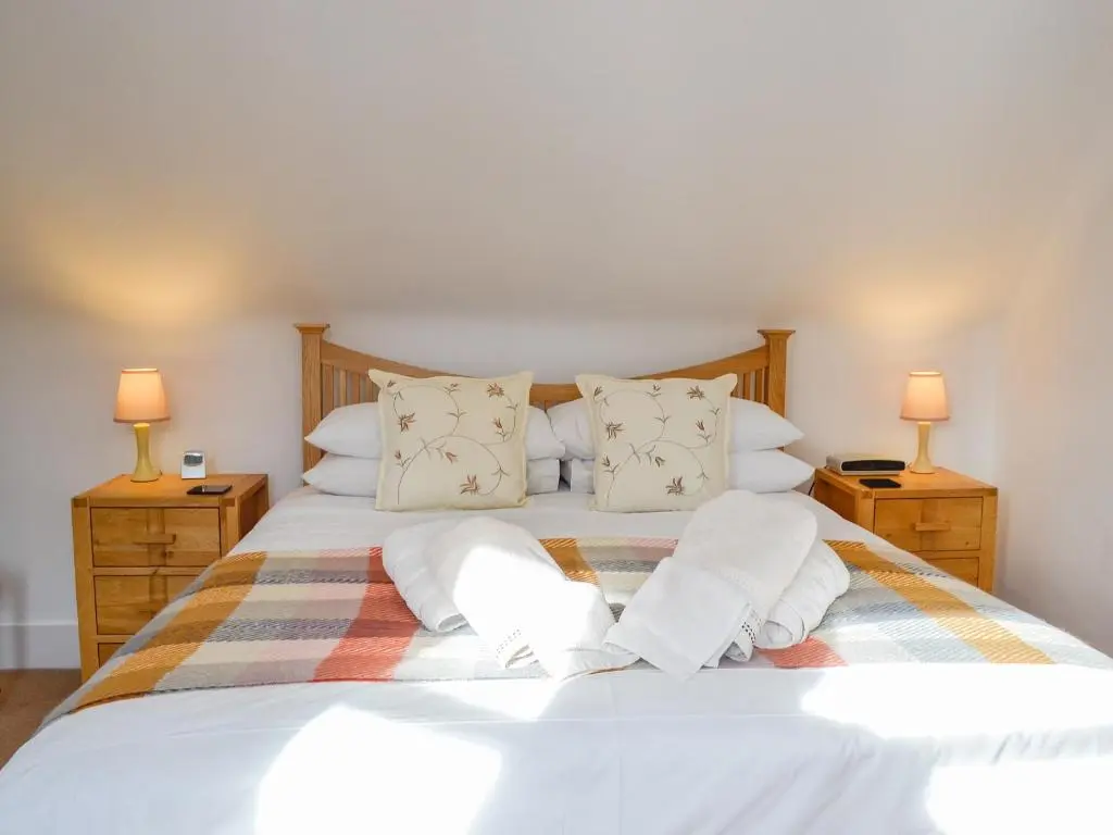 a bedroom with a white bed with two lamps at Craigclunie in Ballater
