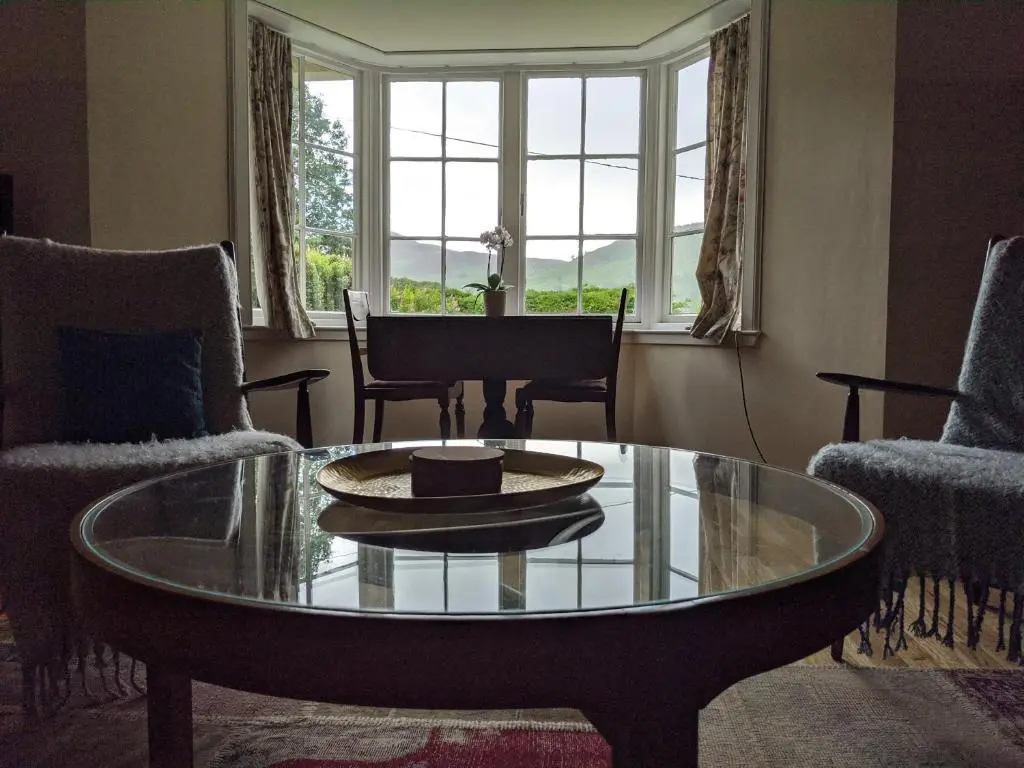 a living room with a glass table and chairs at Thistle Cottage, CrannachCottages in Garve