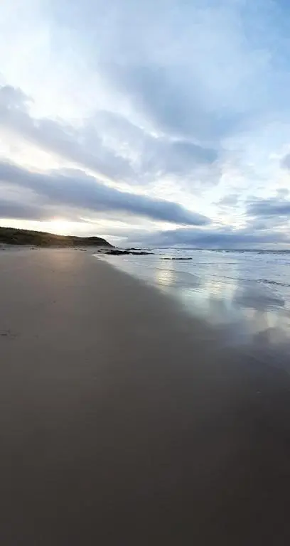 a beach with the sun reflecting in the water at Taid's Retreat Silversands Cove beach lossiemouth in Lossiemouth