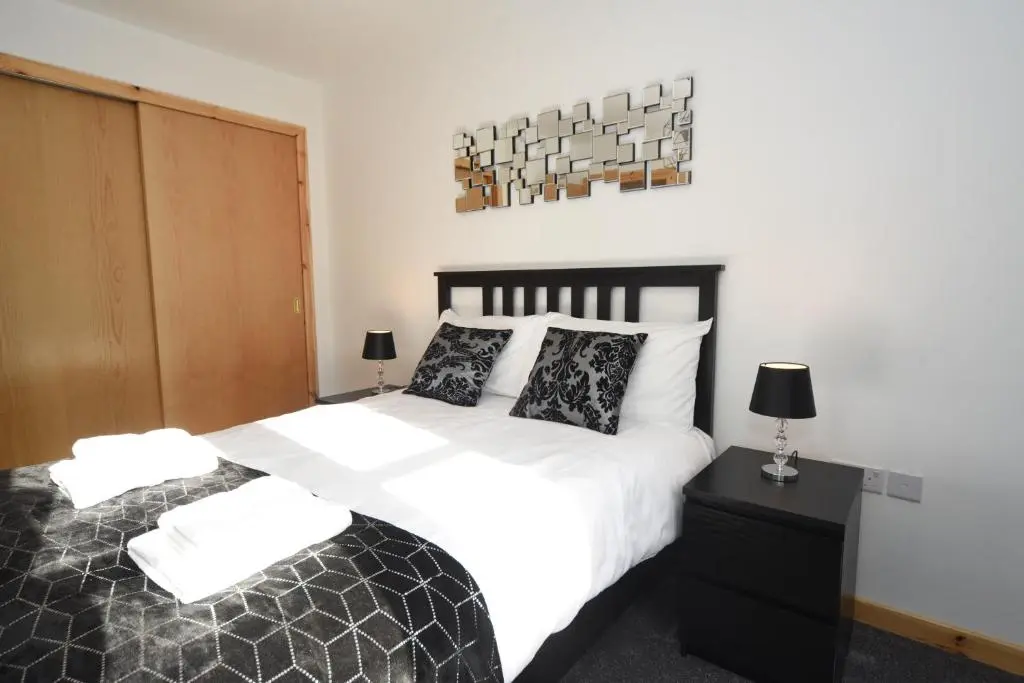 a bedroom with a bed with white sheets and pillows at Silver Key Apartment 2 in Inverness