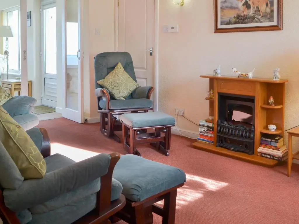a living room with two chairs and a fireplace at White Gables - Uk30688 in Portknockie