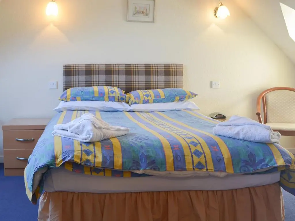 a bedroom with a bed with blue sheets and pillows at White Gables - Uk30688 in Portknockie