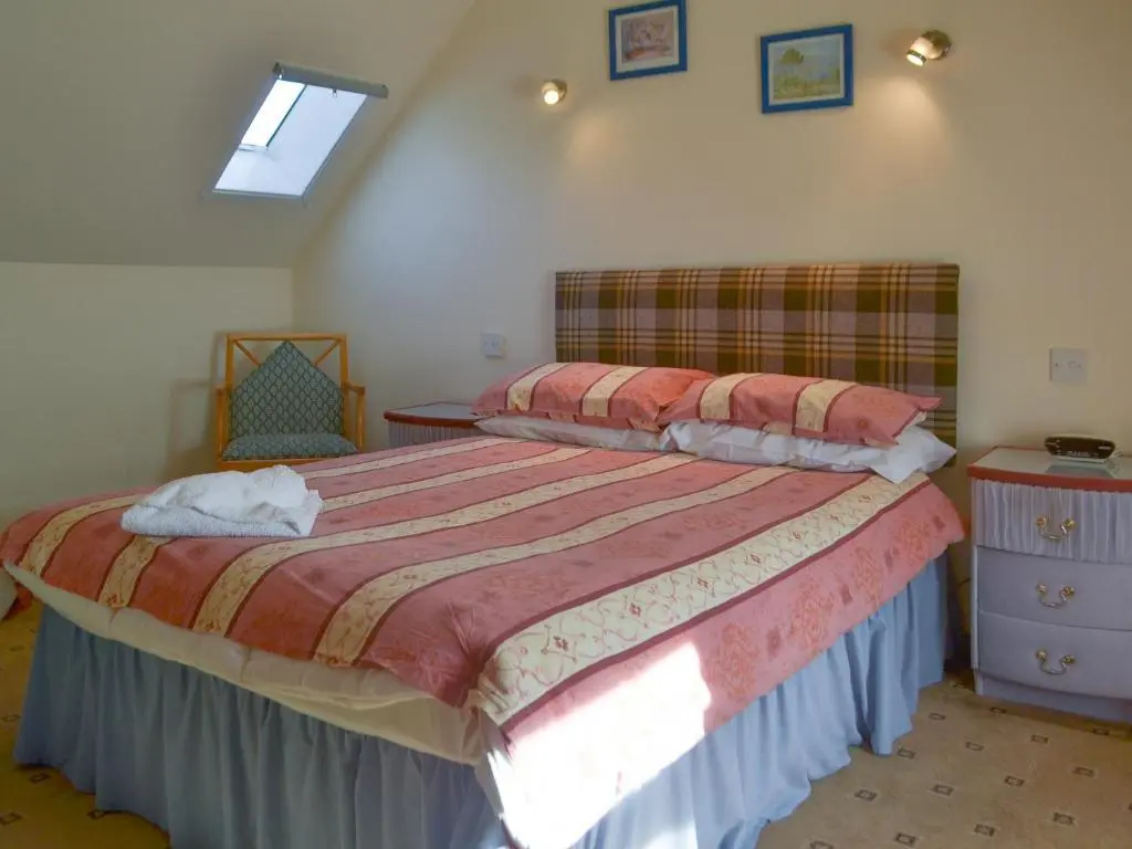 a bedroom with a large bed and a window at Dolphin View - Uk30689 in Portknockie