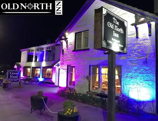 a lit up building with a sign in front of it at Highland HotTub Retreat, on NC500 in Inverness