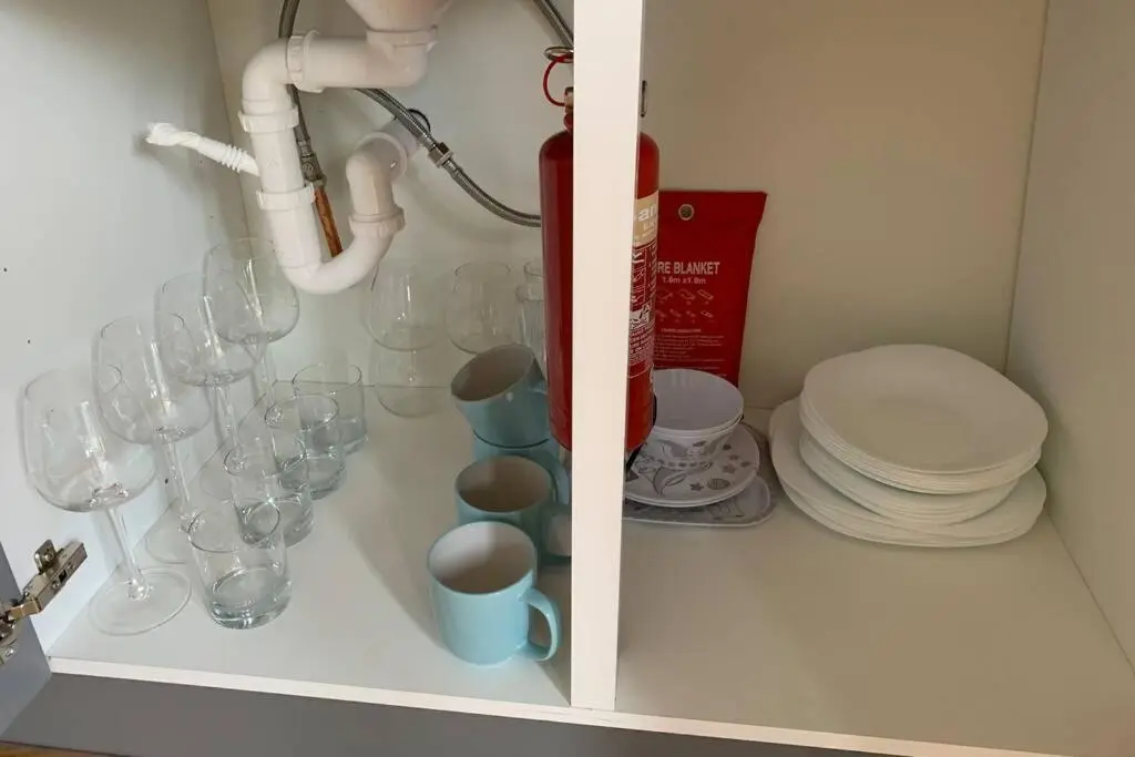 a cabinet filled with glasses and plates and a sink at Highland HotTub Retreat, on NC500 in Inverness
