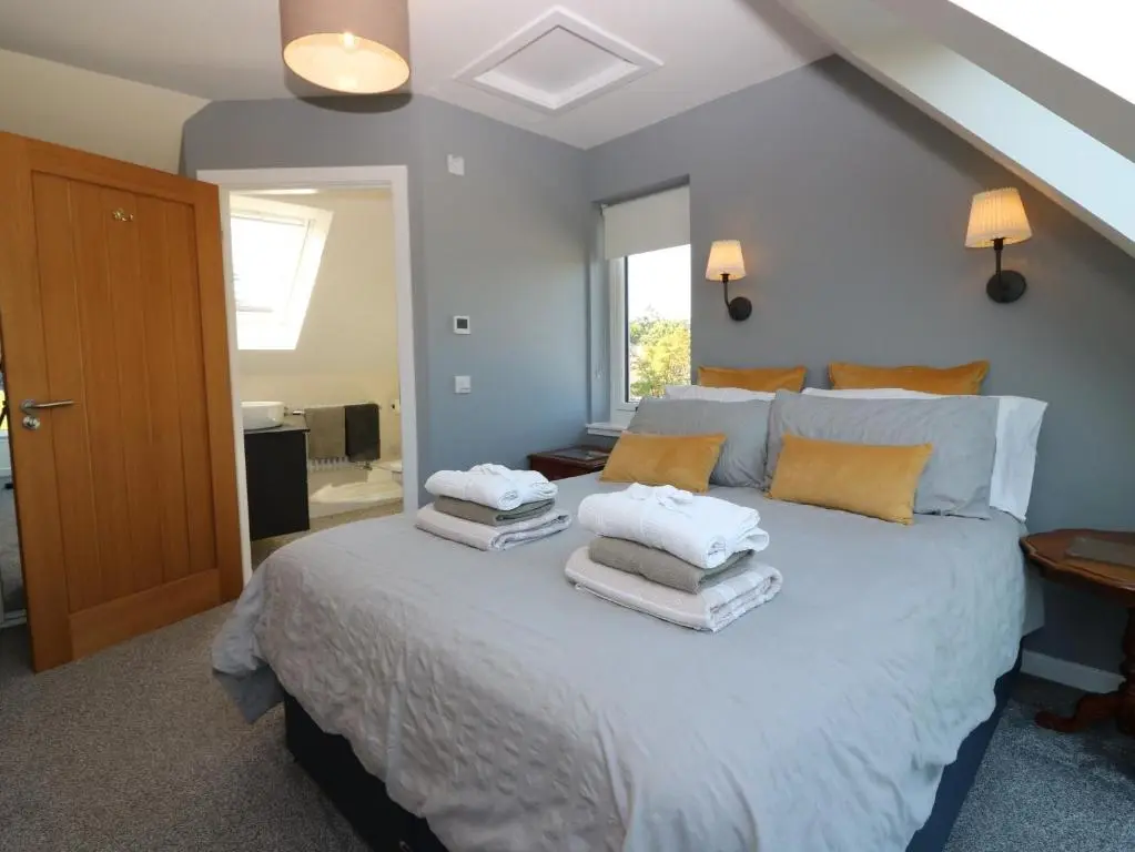 a bedroom with a large bed with towels on it at Berg Cottage in Ballindalloch
