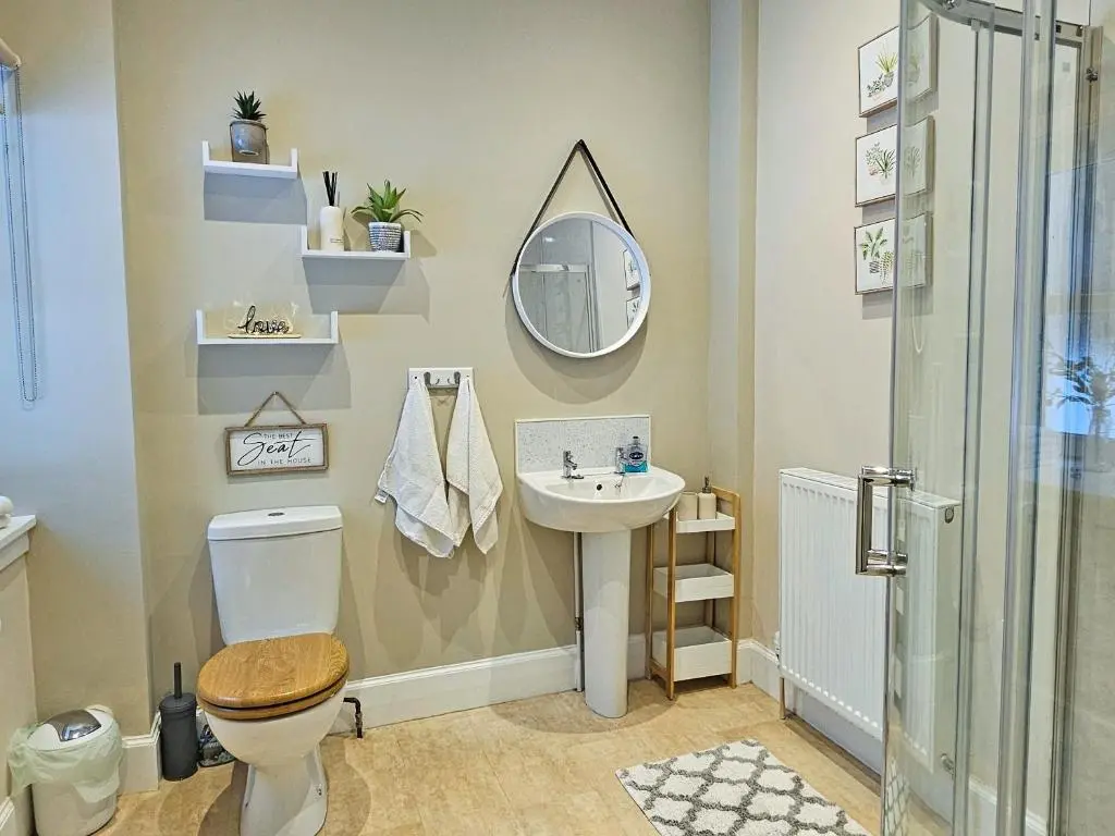 a bathroom with a sink and a toilet and a mirror at Balmore Farmhouse in Lochend
