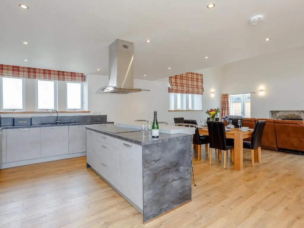 a kitchen and living room with a table and chairs at Auld Kirk Hall in Kirktown of Auchterless