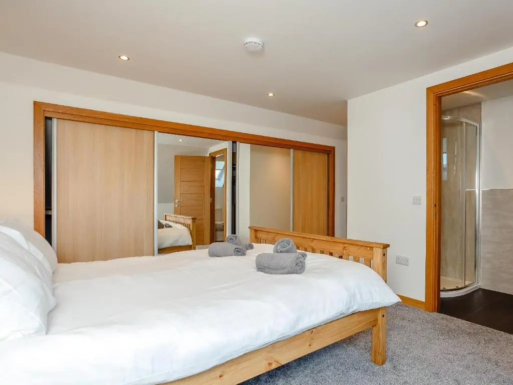 a bedroom with a large white bed with towels on it at Auld Kirk Hall in Kirktown of Auchterless