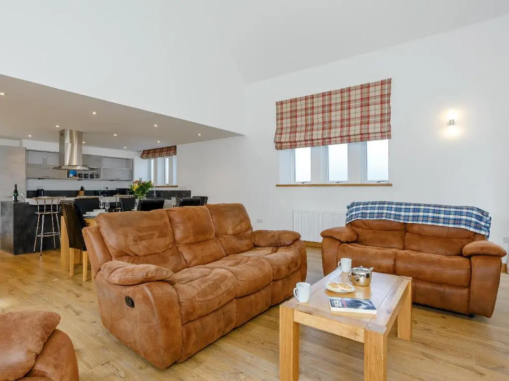a living room with two couches and a table at Auld Kirk Hall in Kirktown of Auchterless