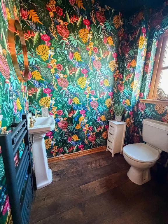 a bathroom with a toilet and a flowery wallpaper at Inverness Holiday House - 2 Bedroom in Inverness