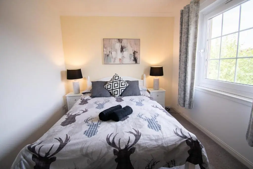 a bedroom with a bed with a deer comforter at Inverness Holiday Retreat - 2 Bedroom in Inverness