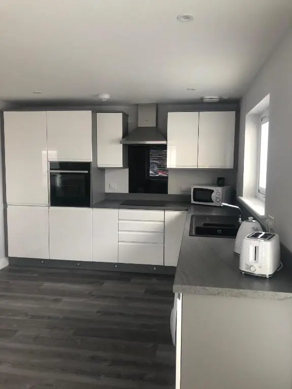 a kitchen with white cabinets and a counter top at Appin Apartment in Inverness