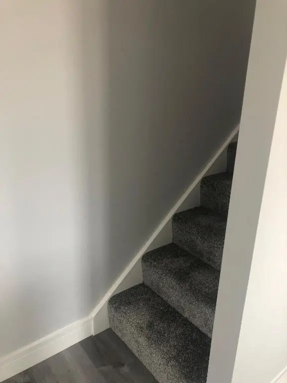 a staircase in a room with grey carpet at Appin Apartment in Inverness