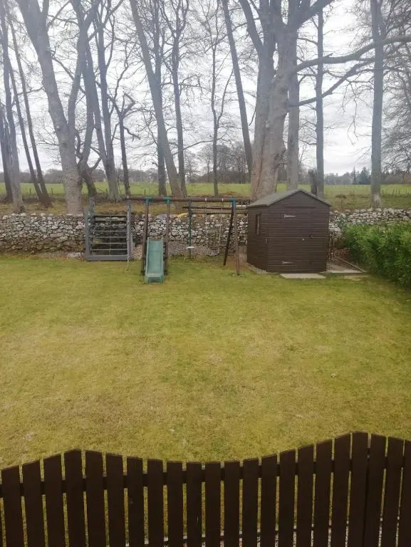 a yard with a fence and a shed at Appin Apartment in Inverness
