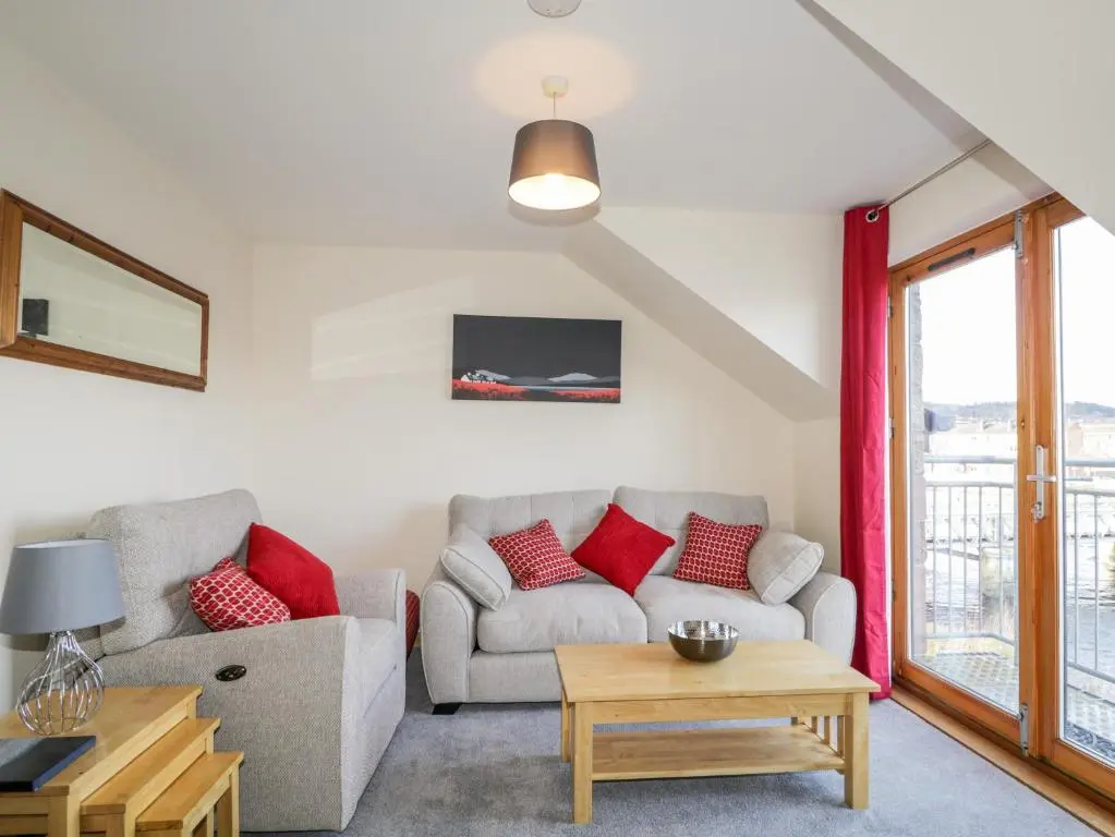 a living room with a couch and a table at Riverview Apartment in Inverness