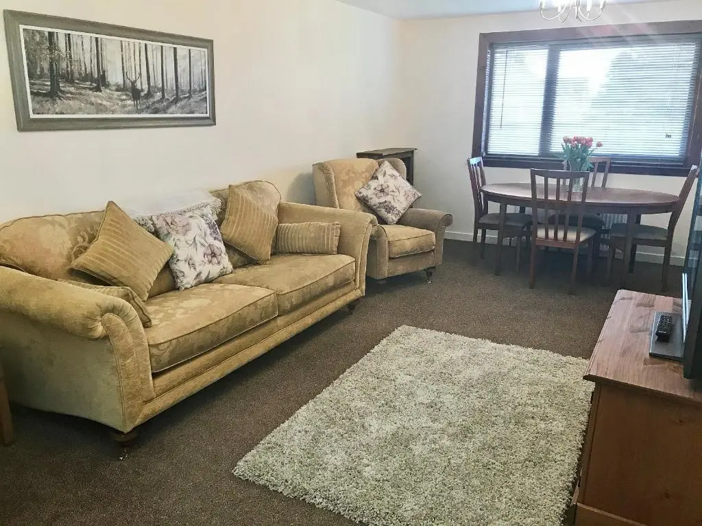 a living room with a couch and a table at Cluaran Cottage in Tain