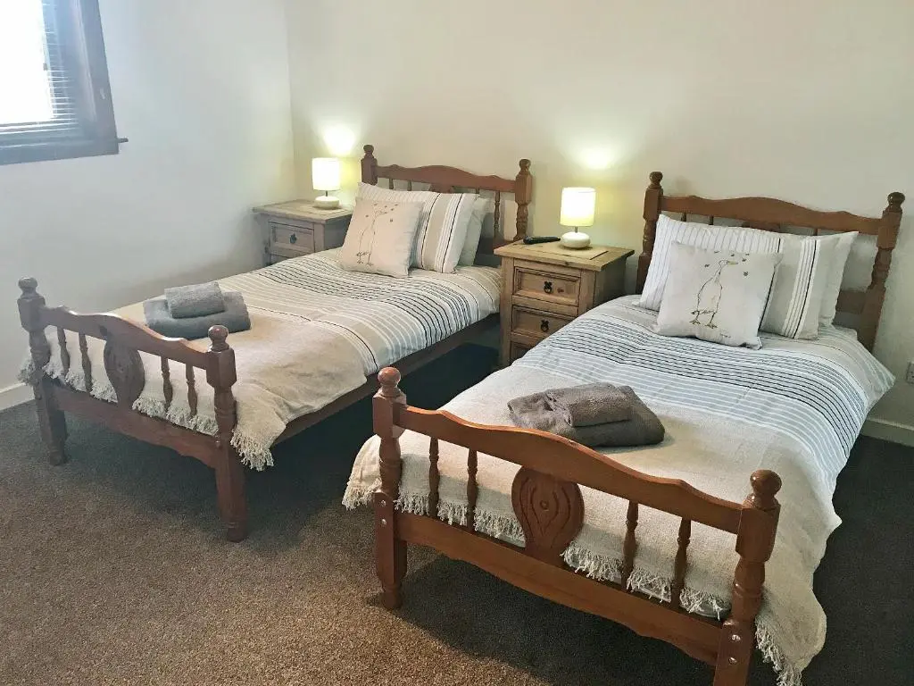 a bedroom with two beds and two night stands at Cluaran Cottage in Tain