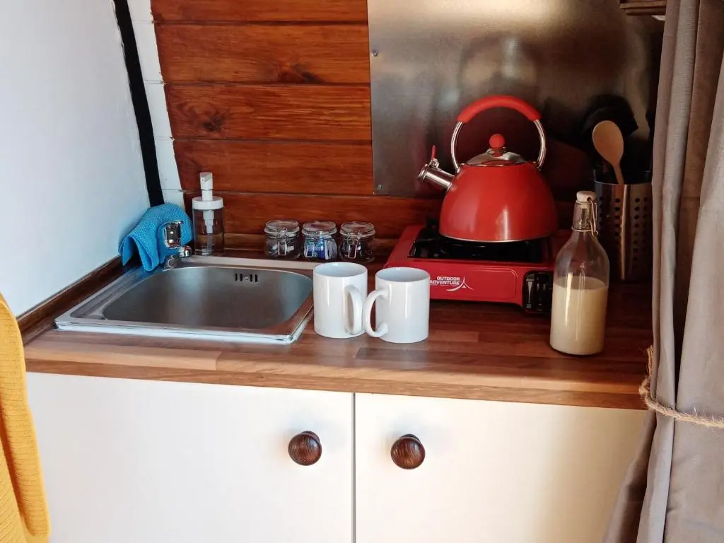 a kitchen counter with a sink and a tea kettle at Wee Hoose Glamping Pod 1 in Skail