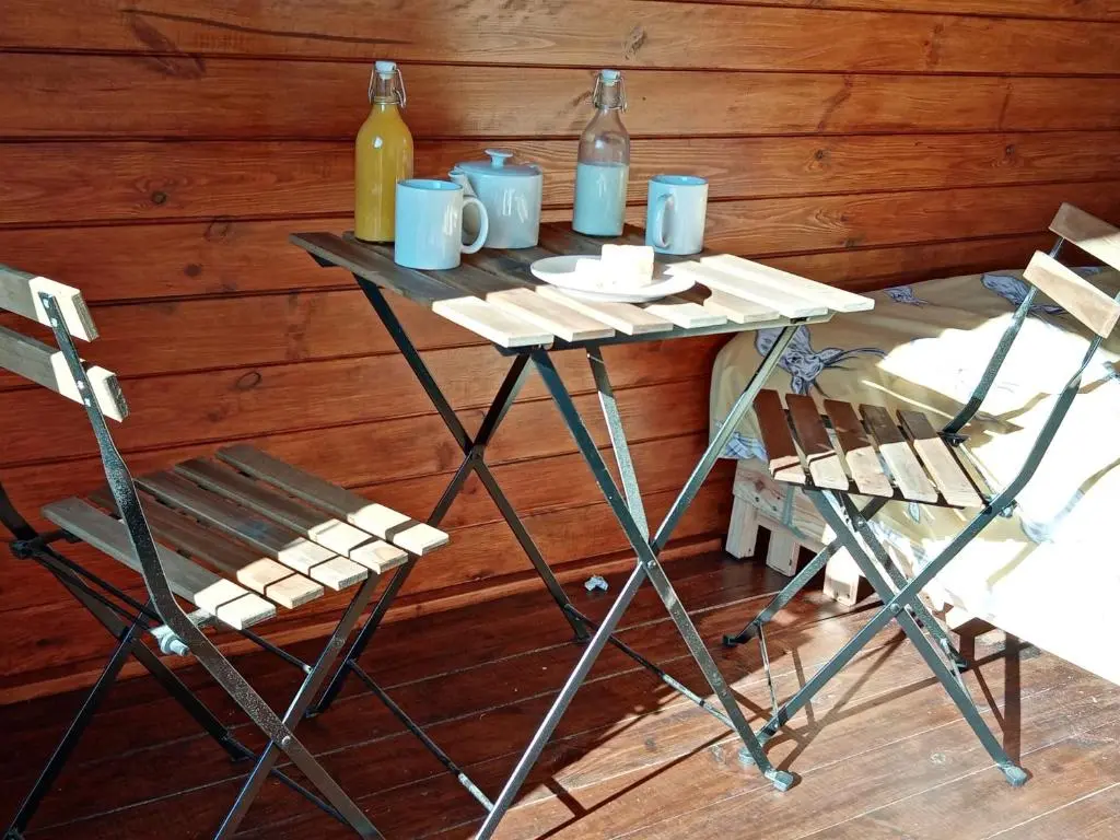 a table with two chairs and two bottles of wine at Wee Hoose Glamping Pod 1 in Skail