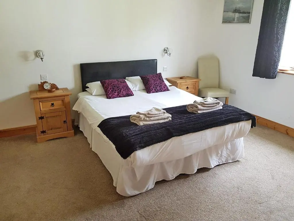 a bedroom with a large bed with towels on it at Pleasant Point in Rosemarkie