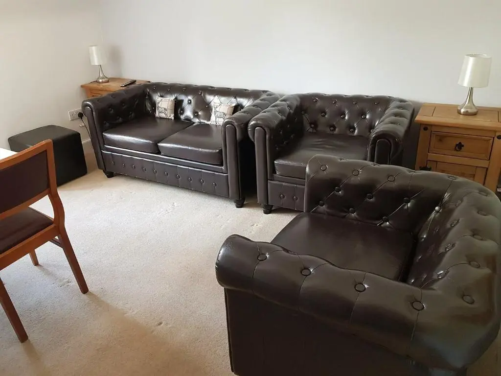 a living room with a leather couch and a chair at The Red Kite - Uk31003 in Avoch