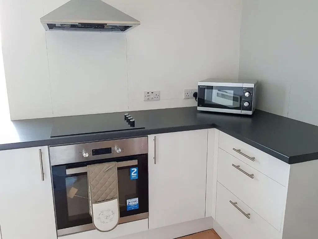 a kitchen with a microwave and a stove at The Red Kite - Uk31003 in Avoch