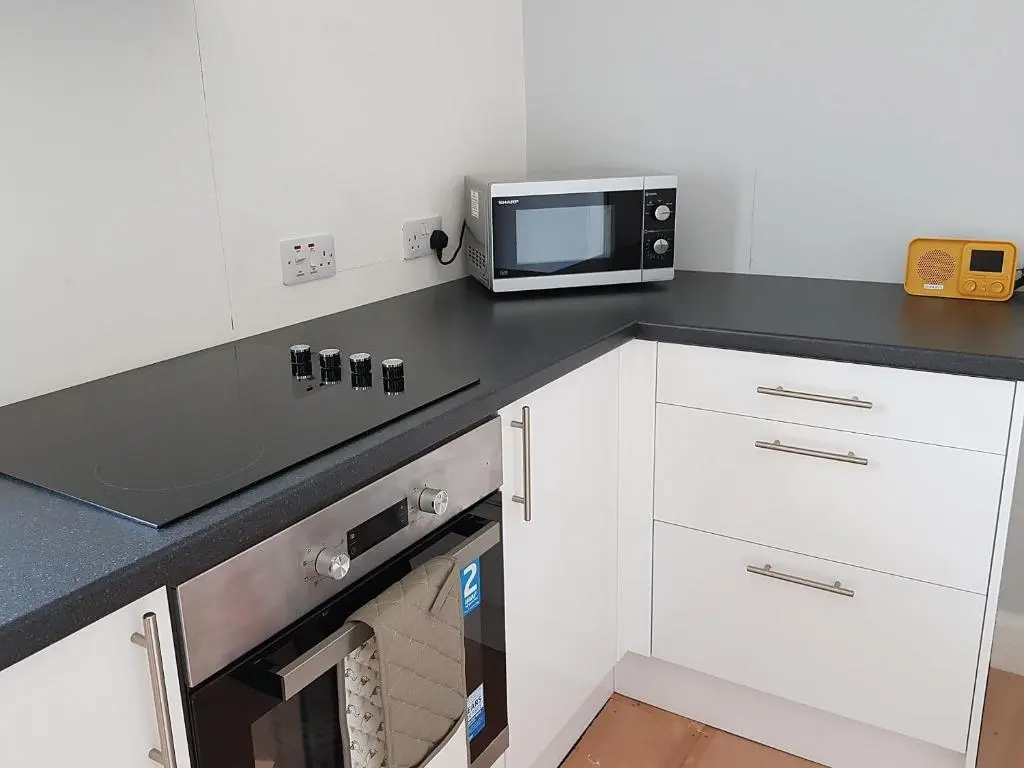 a kitchen with a counter top with a microwave at The Red Kite - Uk31003 in Avoch