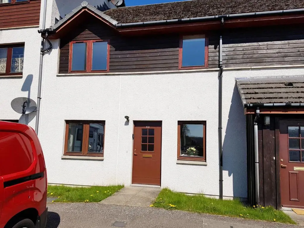 a white house with a red door and windows at Caledonian 2 bedroom free parking in Inverness